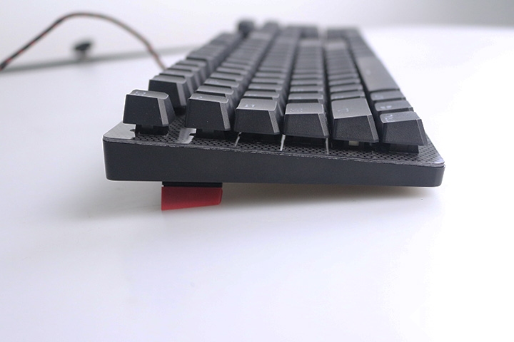得益于键盘底部的4块防滑垫,以及脚撑上的红色垫子,鲜艳红色与logo的