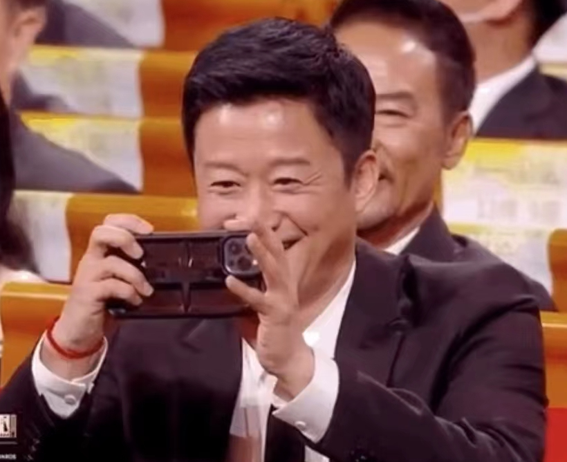 中兴手机代言人吴京在电影节玩iPhone笑出鱼尾纹